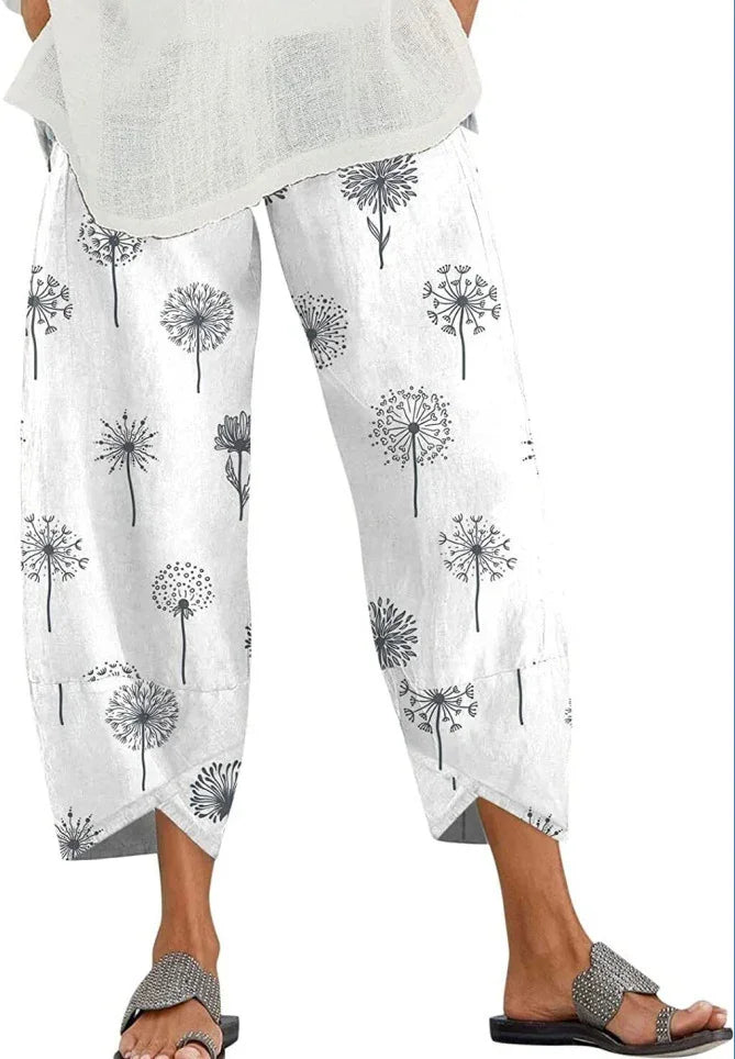 White cropped pants with black dandelion print, paired with gray sandals and light top