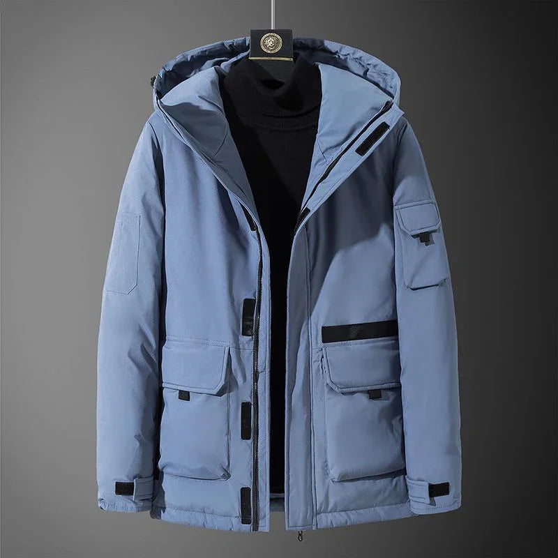 Light blue men's winter jacket with hood and multiple black zippered pockets on grey background