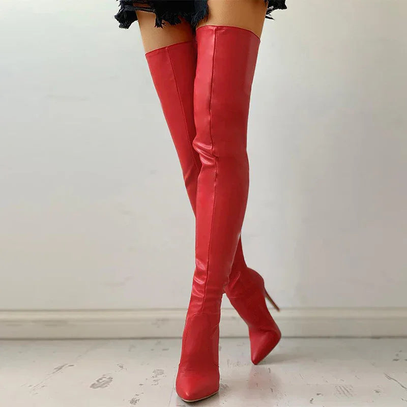 woman wearing vibrant red thigh-high leather stiletto boots with pointed toes on light floor