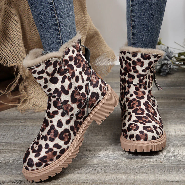 Leopard print ankle boots with beige fur lining and chunky tan soles worn with blue jeans