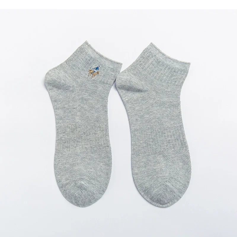 Pair of grey ankle socks with embroidered polo player logo on a white background