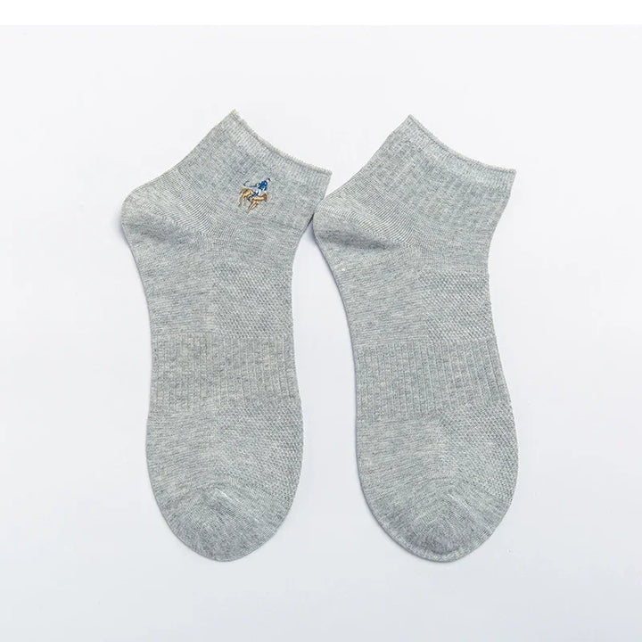 Pair of grey ankle socks with embroidered polo player logo on a white background