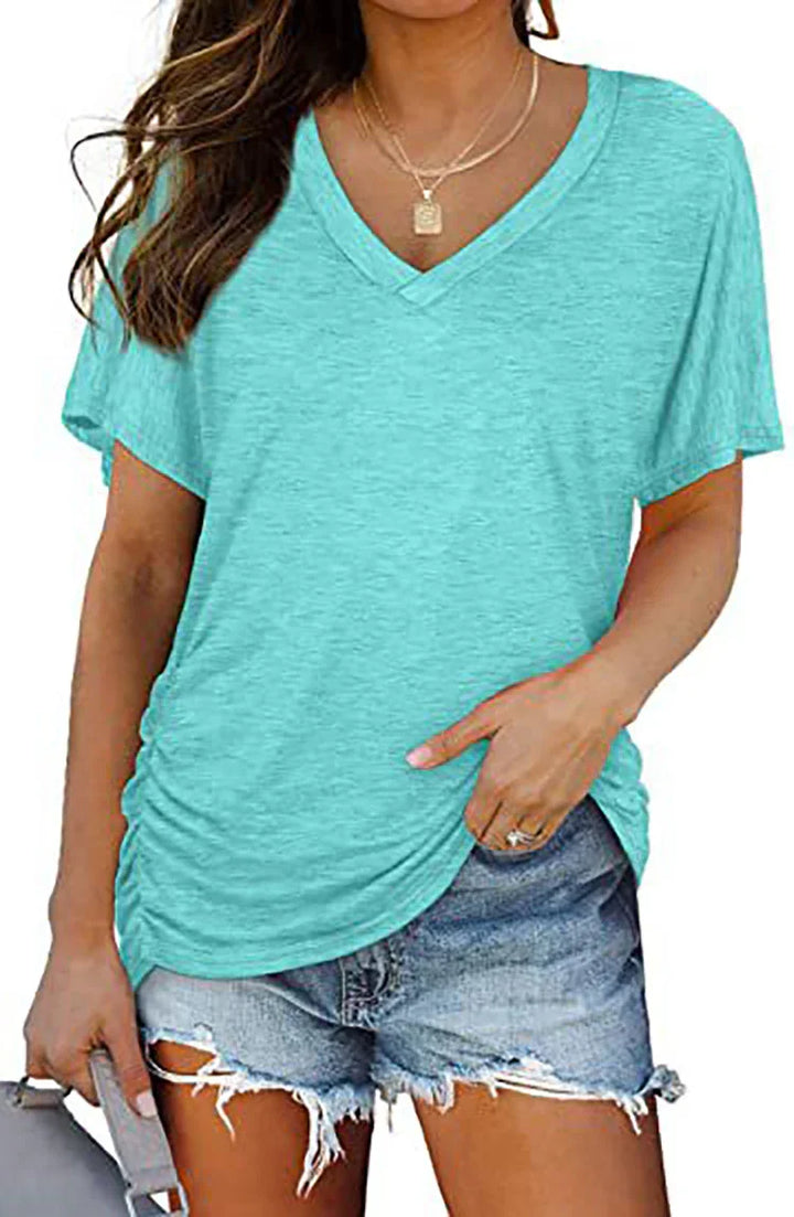Woman wearing a casual light blue V-neck t-shirt with short sleeves and distressed denim shorts