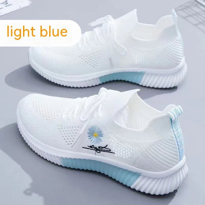 White knit sneakers with light blue soles and floral embroidery on side, light blue label at heel