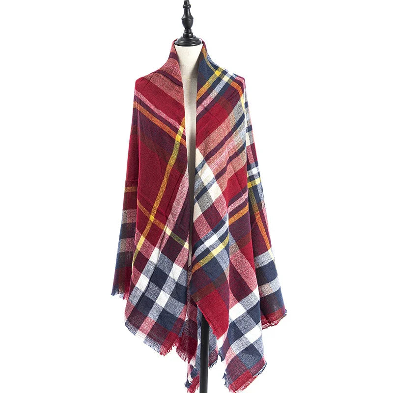 Red and navy plaid wool shawl displayed on black mannequin against white background