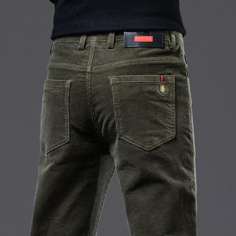 Close-up of olive green corduroy pants with back pockets and leather brand patch on waist
