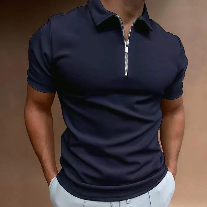 Man wearing navy blue short-sleeve polo shirt with silver zipper and light gray pants