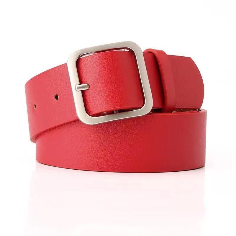 Red leather belt with silver square buckle on white background