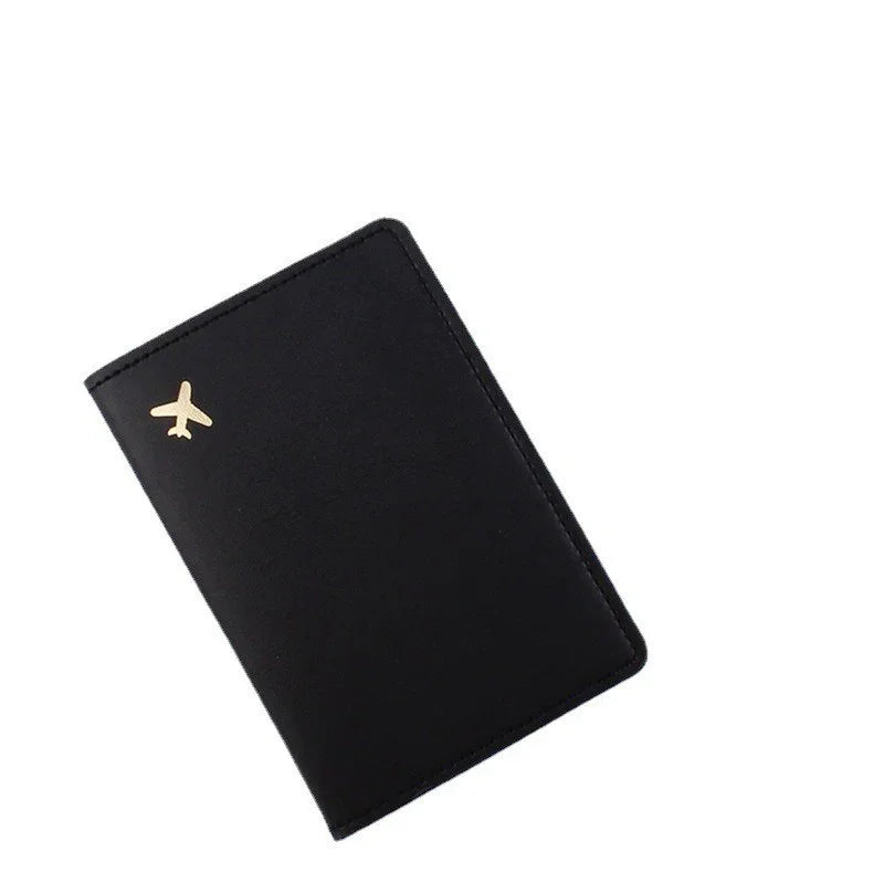 Black leather travel passport holder with small gold airplane icon on cover