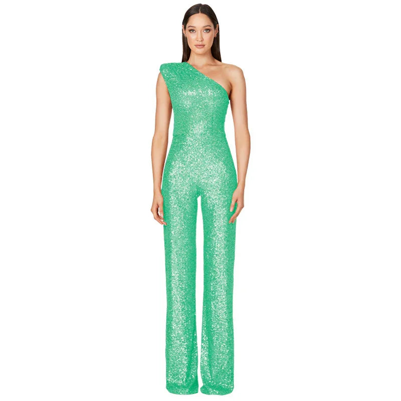 Woman wearing green one-shoulder sequin jumpsuit with wide-leg pants on white background