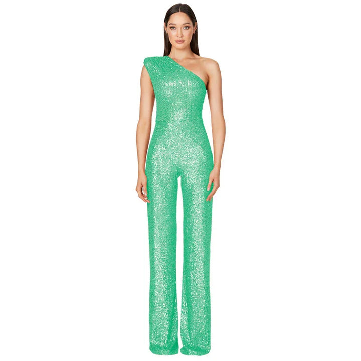 Woman wearing green one-shoulder sequin jumpsuit with wide-leg pants on white background