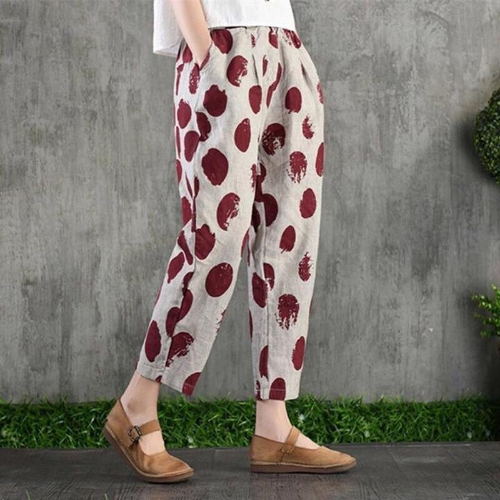 Person wearing beige pants with large maroon polka dots and brown Mary Jane shoes against concrete background