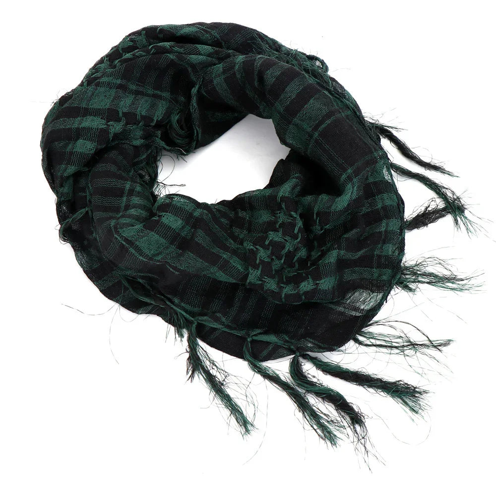 Black and green checkered cotton scarf with fringed edges rolled on white background