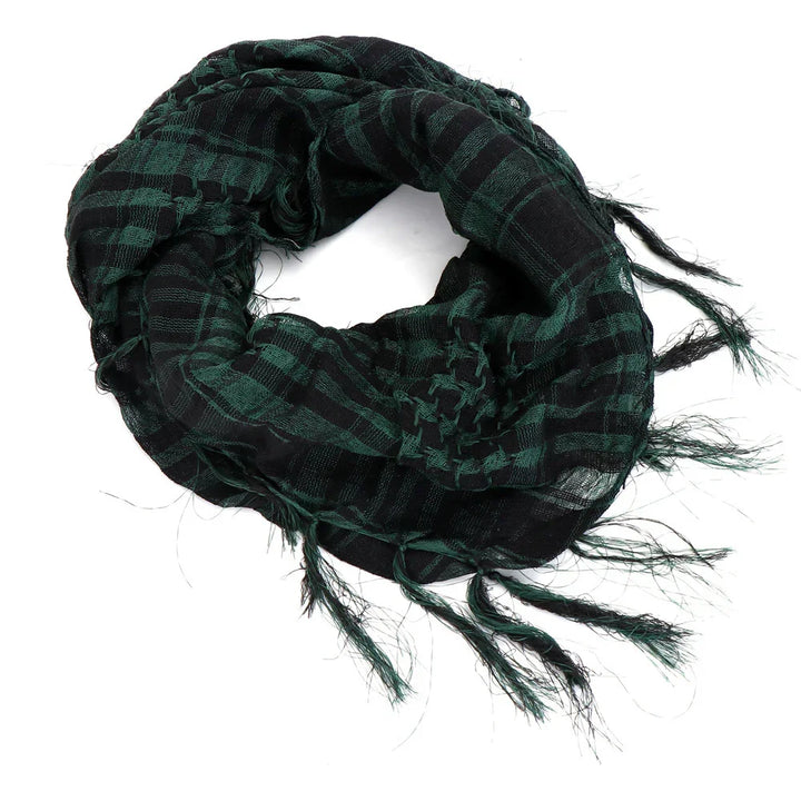 Black and green checkered cotton scarf with fringed edges rolled on white background