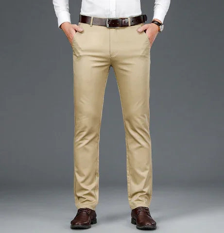 Men's beige formal trousers paired with a white shirt, brown belt, and brown dress shoes