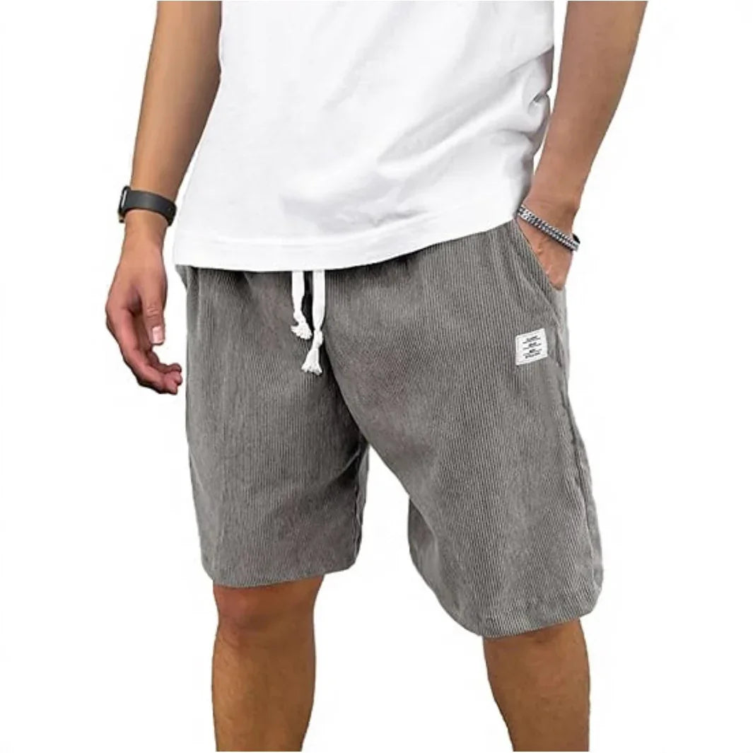 Man wearing gray striped drawstring shorts and white t-shirt, casual summer outfit