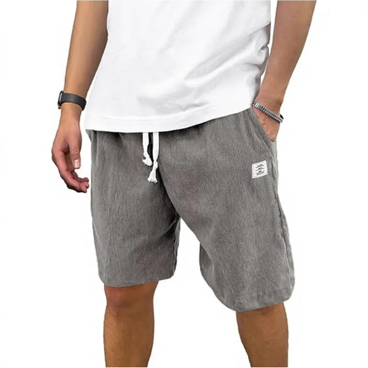 Man wearing gray striped drawstring shorts and white t-shirt, casual summer outfit