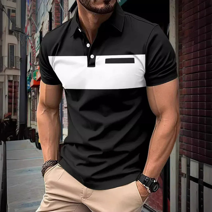 Muscular man wearing black and white color block polo shirt with beige pants in urban street setting