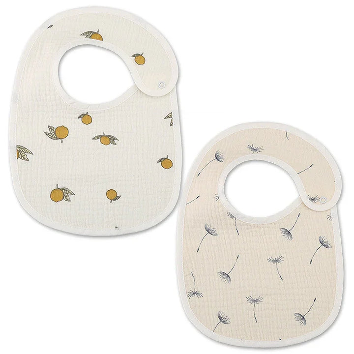 Two baby bibs with snap closures, one with orange fruit print, one with dandelion seed design