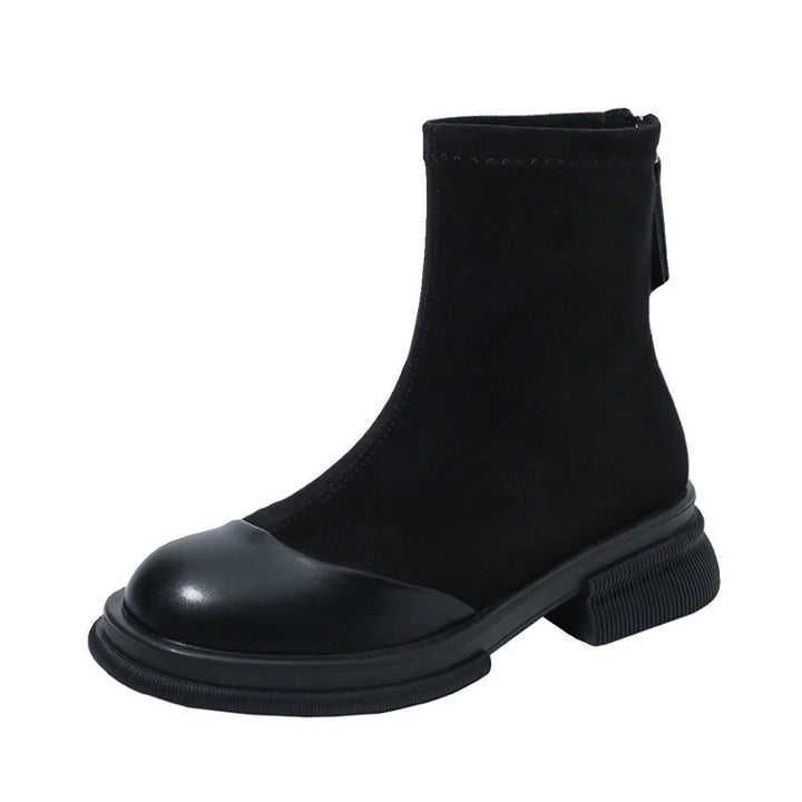 Black ankle boot with suede upper and smooth leather toe cap, chunky sole, and zipper closure