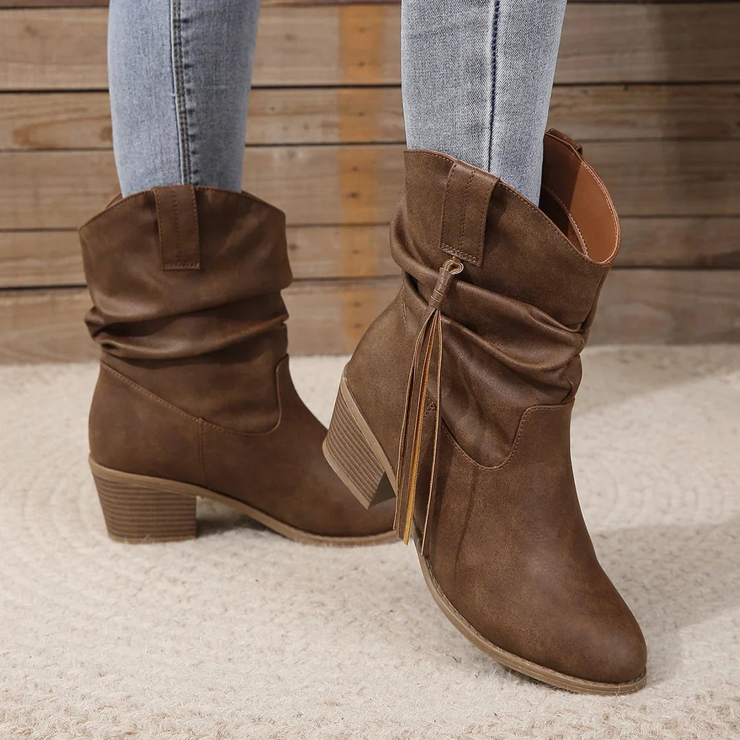 Brown slouchy ankle boots with tassel detail and block heels worn with light wash jeans