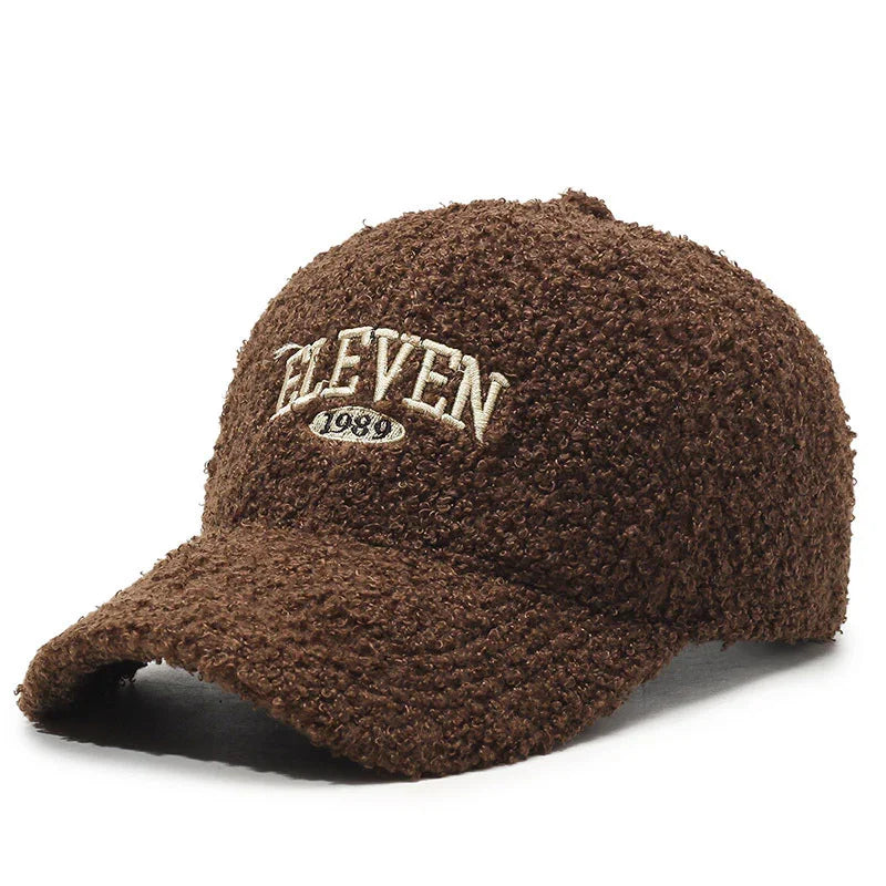 Brown textured wool baseball cap with curved brim and embroidered white text 'ELEVEN 1989'
