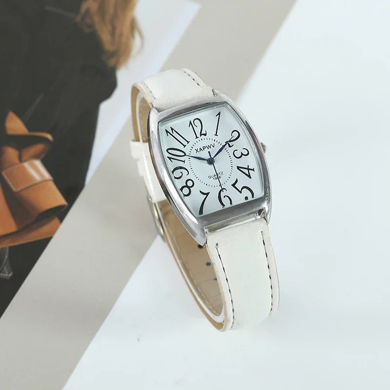 White leather strap wristwatch with silver curved rectangular case and large black numerals on white dial