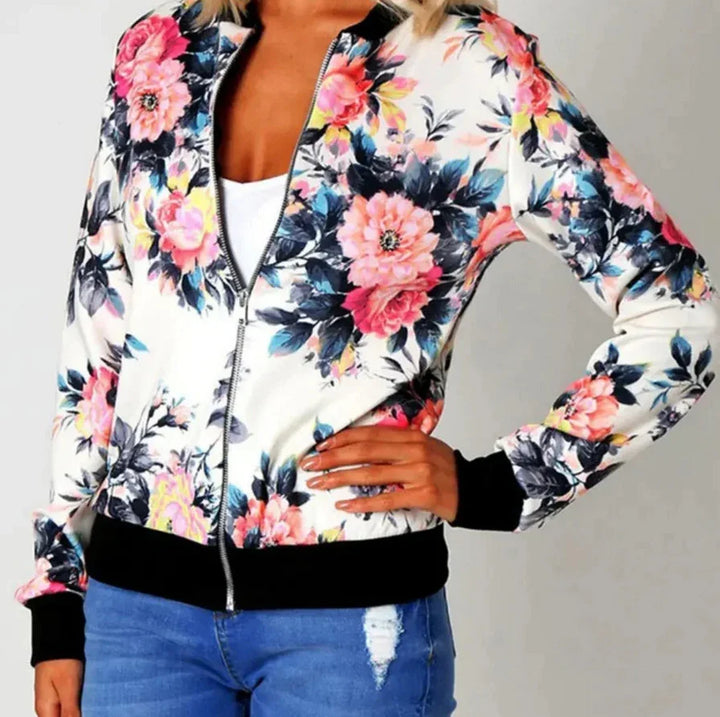 woman wearing white floral zip-up bomber jacket with black trim and blue distressed jeans
