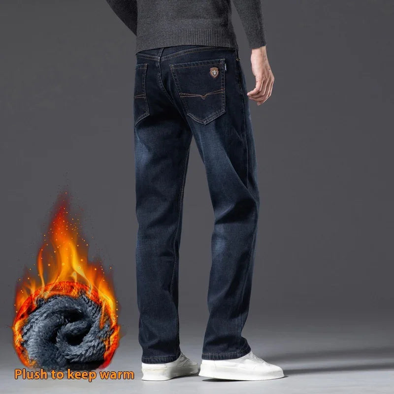 Man wearing dark blue warm plush lined jeans standing against gray background with fire graphic indicating warmth