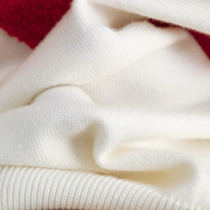 Close-up of soft white knit fabric with red trim edge, highlighting texture and detail