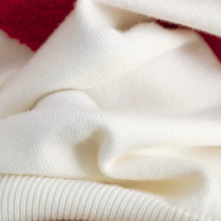 Close-up of soft white knit fabric with red trim edge, highlighting texture and detail