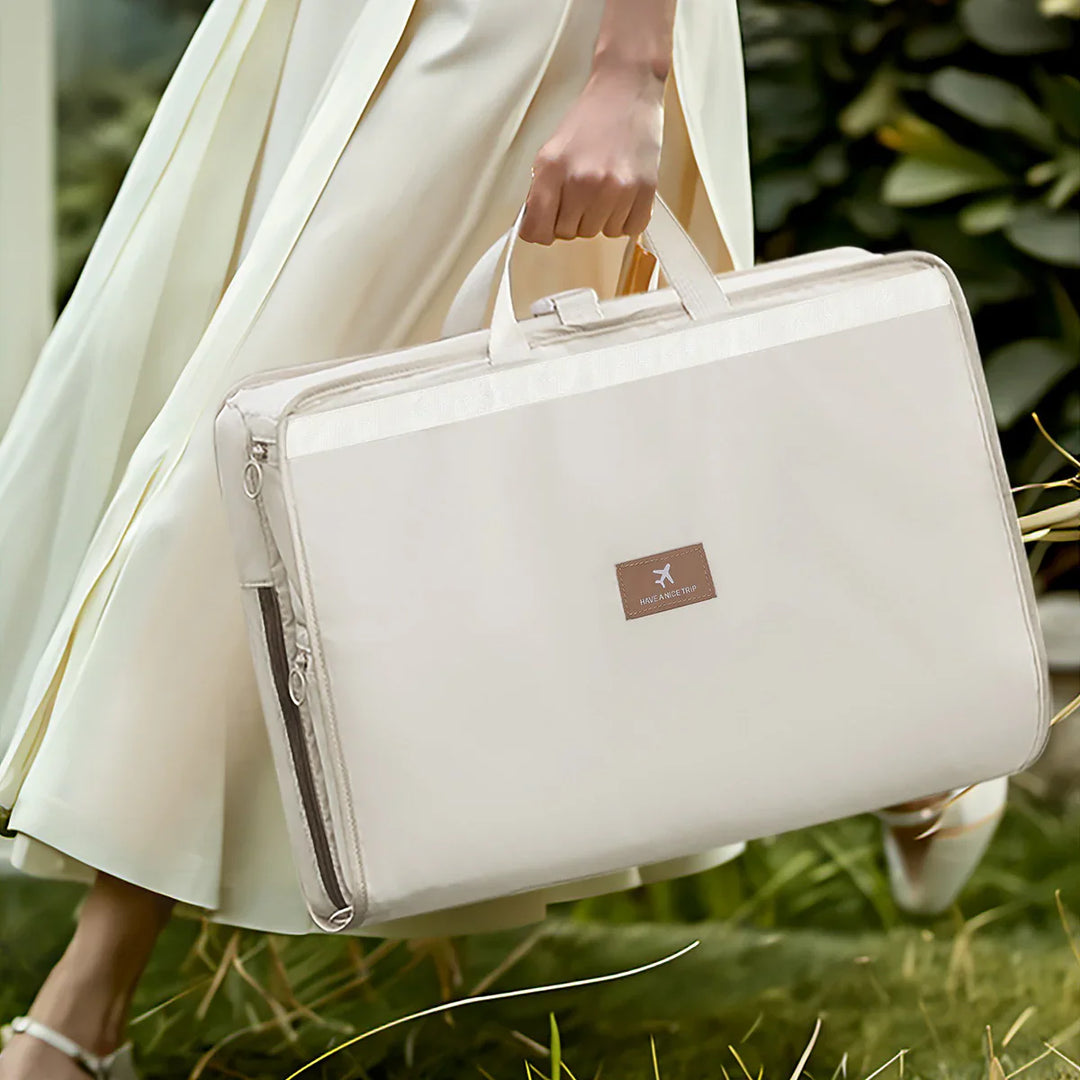 Woman in cream dress holding beige travel bag with 'Have a nice trip' label outdoors