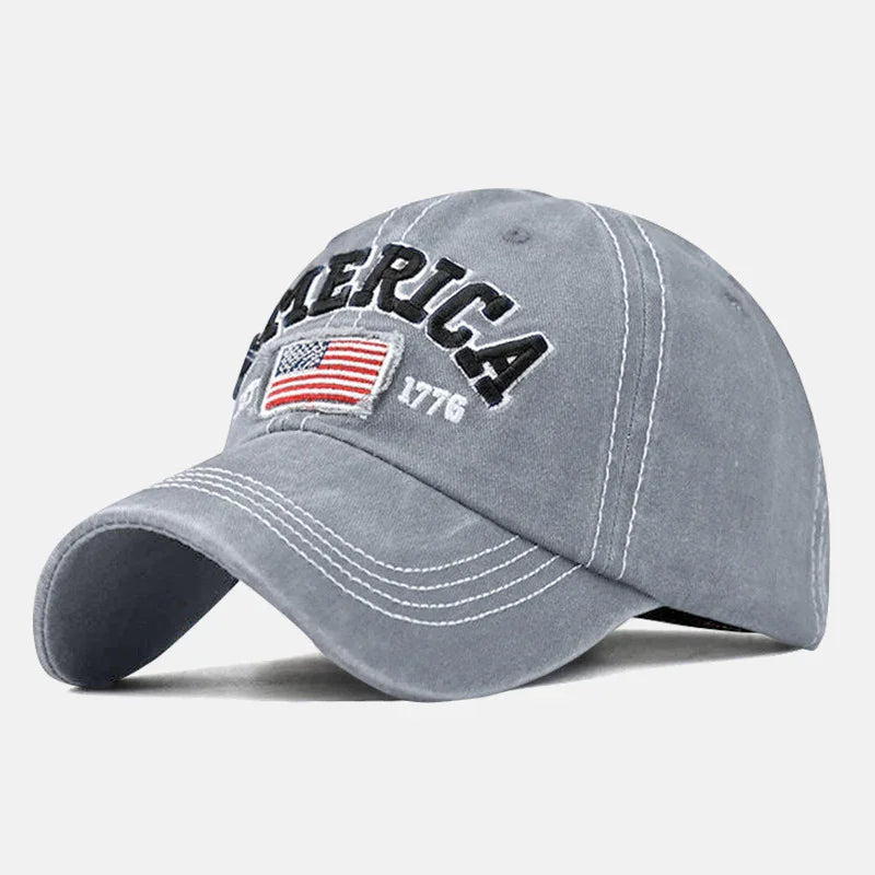 Gray baseball cap with white stitching, embroidered American flag, and text AMERICA 1776