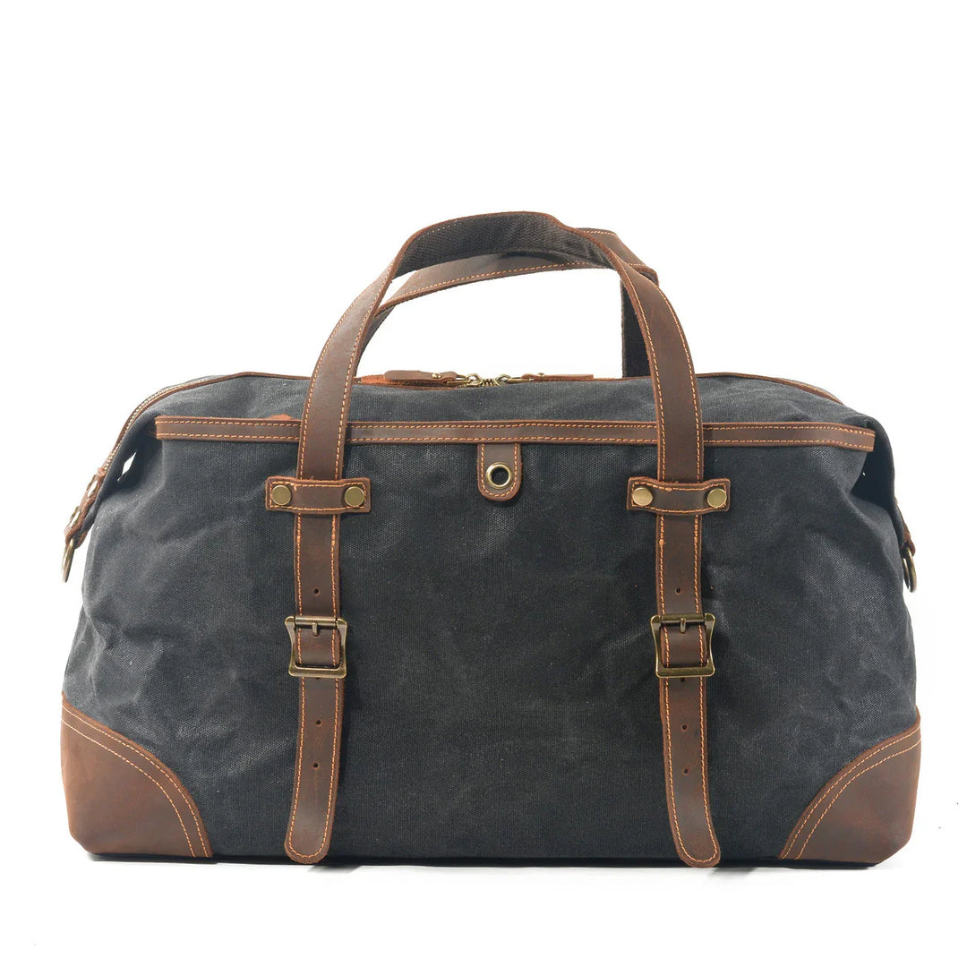 Black canvas and brown leather weekend duffel bag with brass buckles and handles