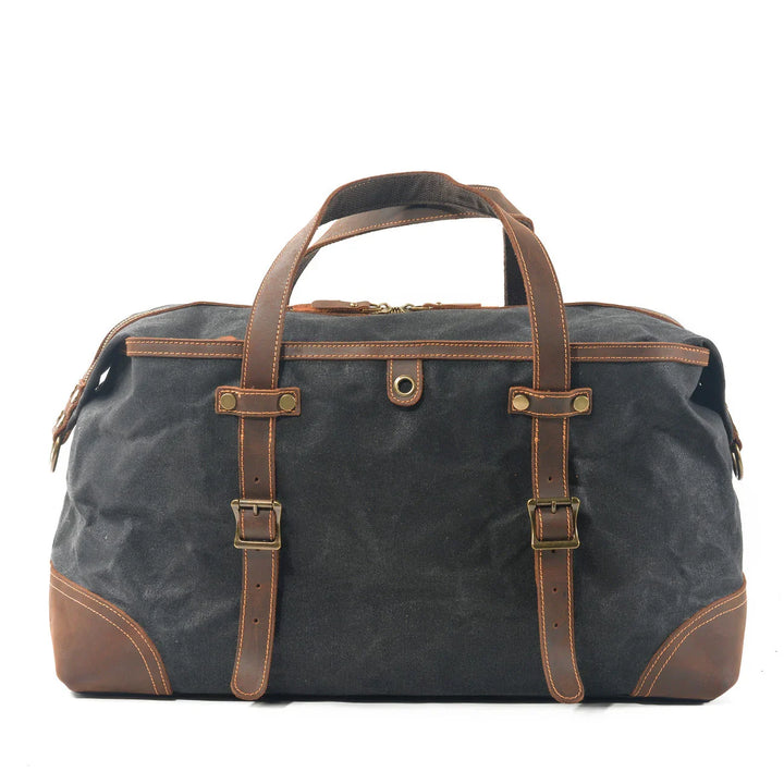 Black canvas and brown leather weekend duffel bag with brass buckles and handles