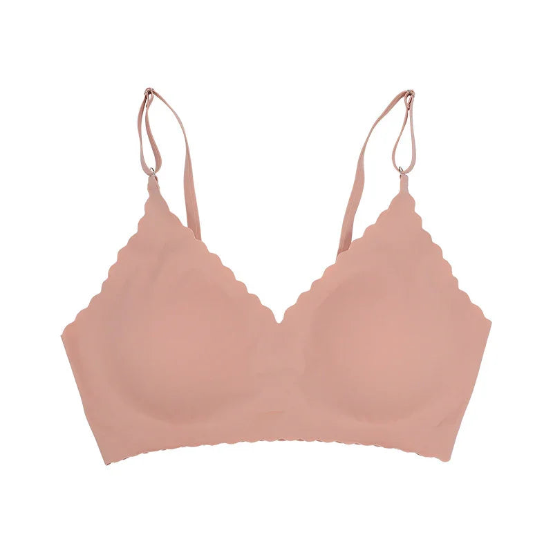 nude seamless wireless bra with scalloped edges and adjustable straps on white background