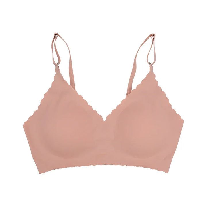 nude seamless wireless bra with scalloped edges and adjustable straps on white background