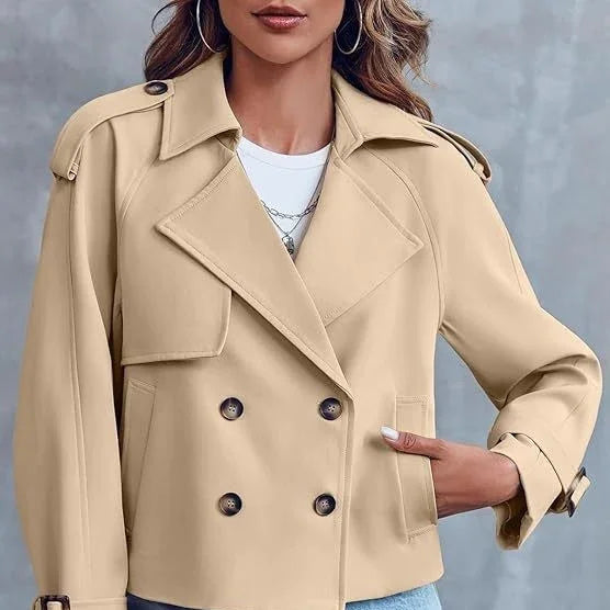 Woman wearing beige double-breasted cropped trench coat with button and pocket details