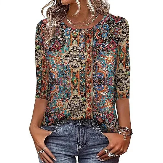 Woman wearing colorful boho floral paisley 3/4 sleeve blouse with round neckline and denim jeans