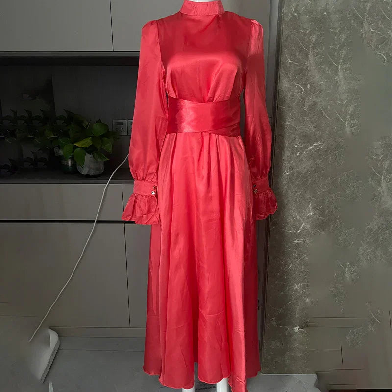 Long red satin dress with high neck, puff sleeves, and wide waistband on mannequin