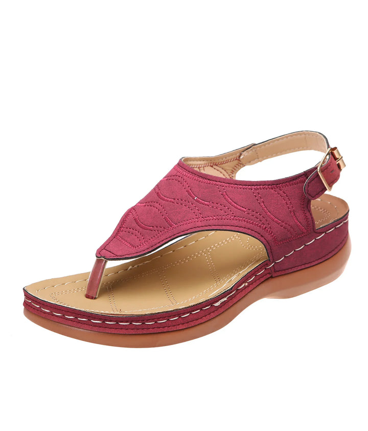 Red cushioned leather sandal with decorative stitching and adjustable back strap