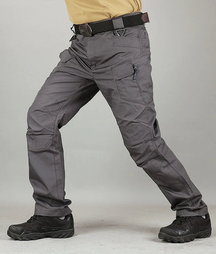 Man wearing gray tactical pants with multiple pockets and black tactical shoes