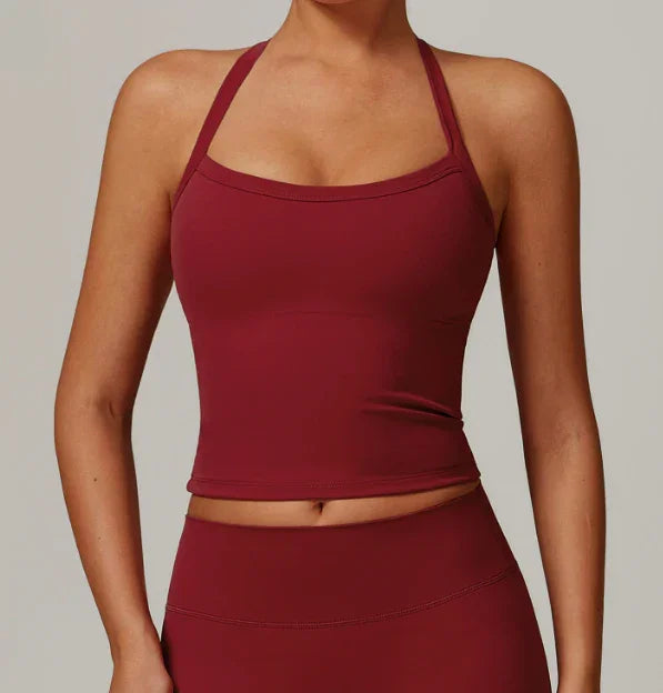 Woman wearing a fitted burgundy halter crop top and matching high-waisted leggings