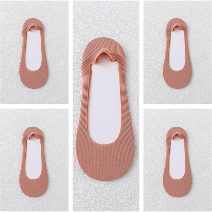 Light brown ribbed no-show socks with scalloped edge and silicone heel grips on white background