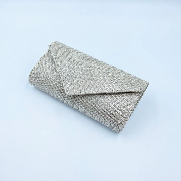 silver glittery envelope clutch purse with triangular flap on white background