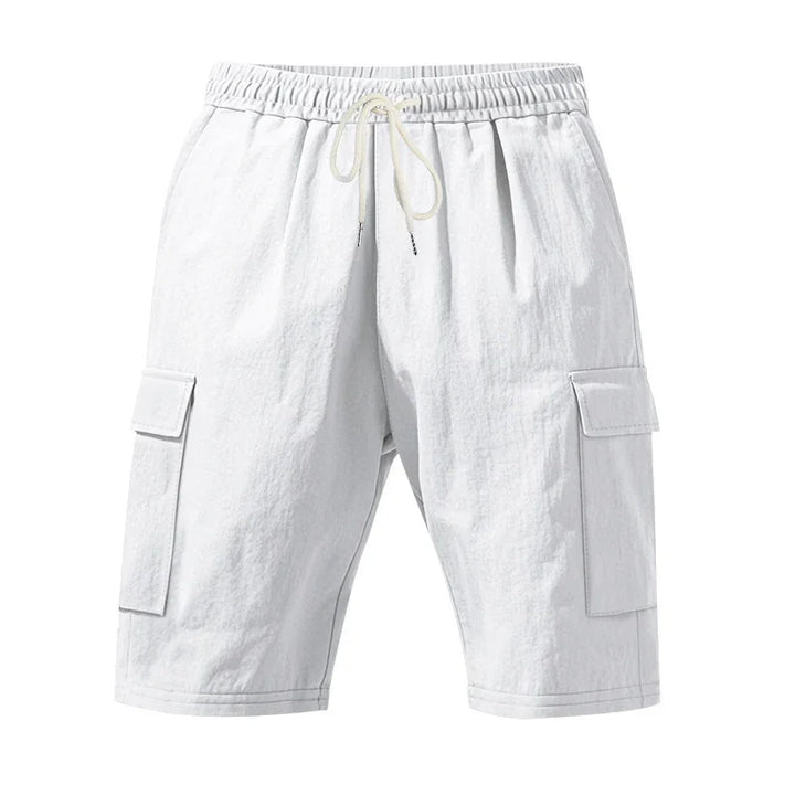 White cargo shorts with elastic waistband and drawstring, featuring side flap pockets