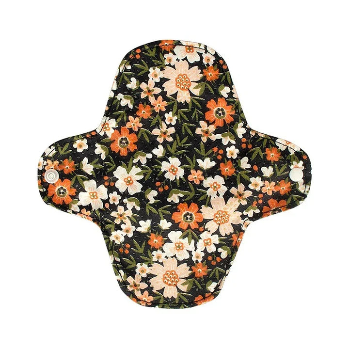 Reusable cloth menstrual pad with black background and orange and white floral pattern