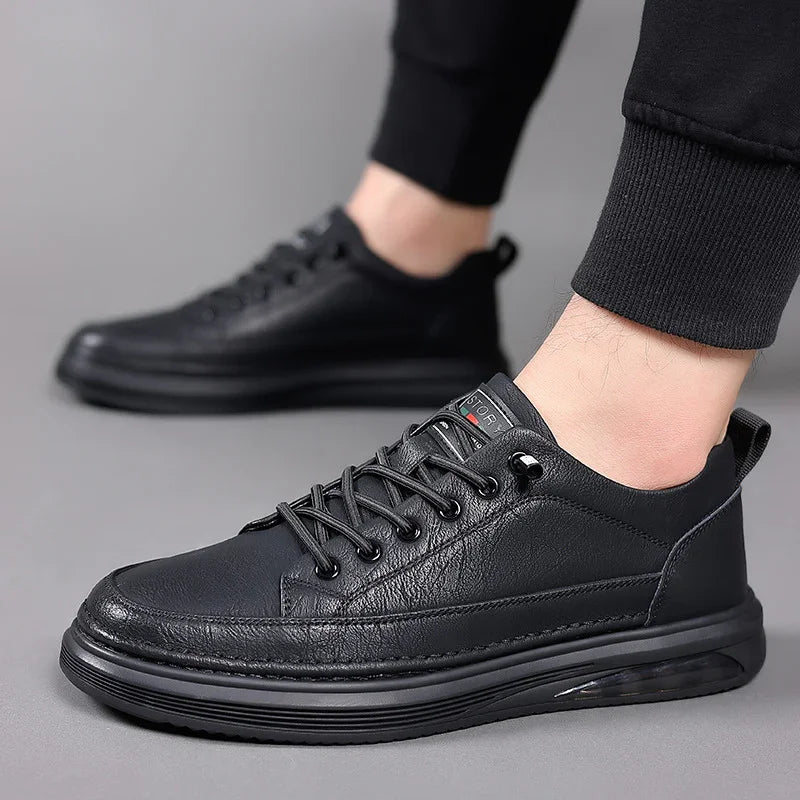 Close-up of stylish black leather casual sneakers with black laces on a person wearing black pants
