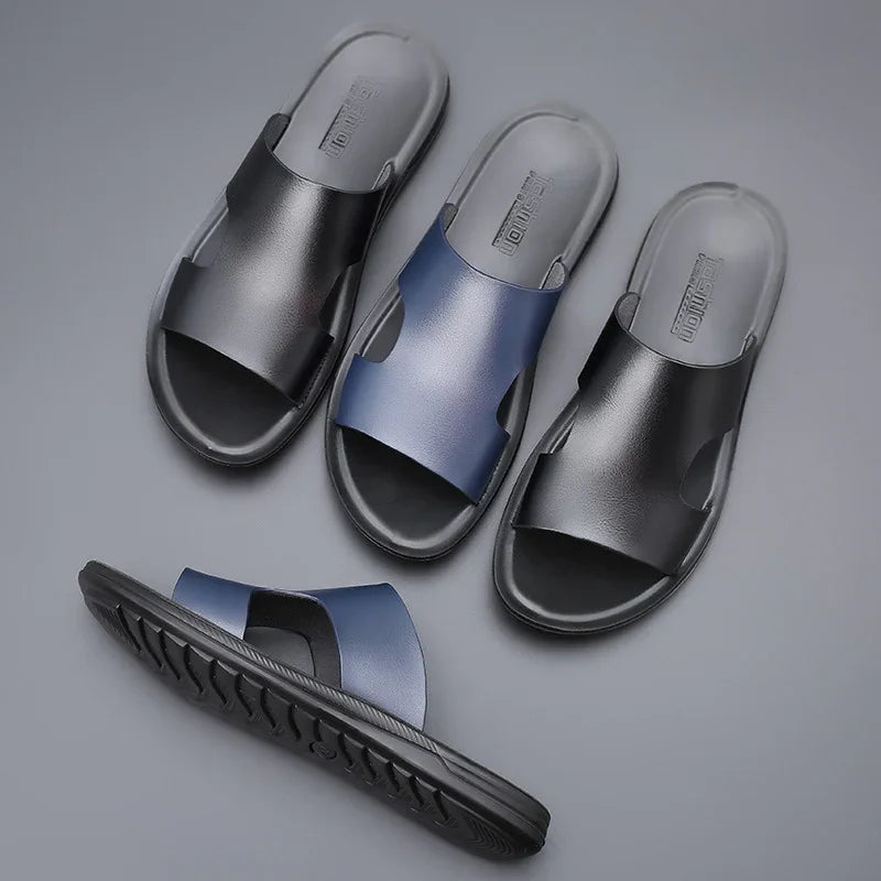 Three pairs of men's slip-on sandals in black and navy blue with textured soles on gray background