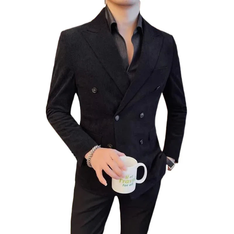 Man wearing black double-breasted suit and dark shirt holding white coffee mug